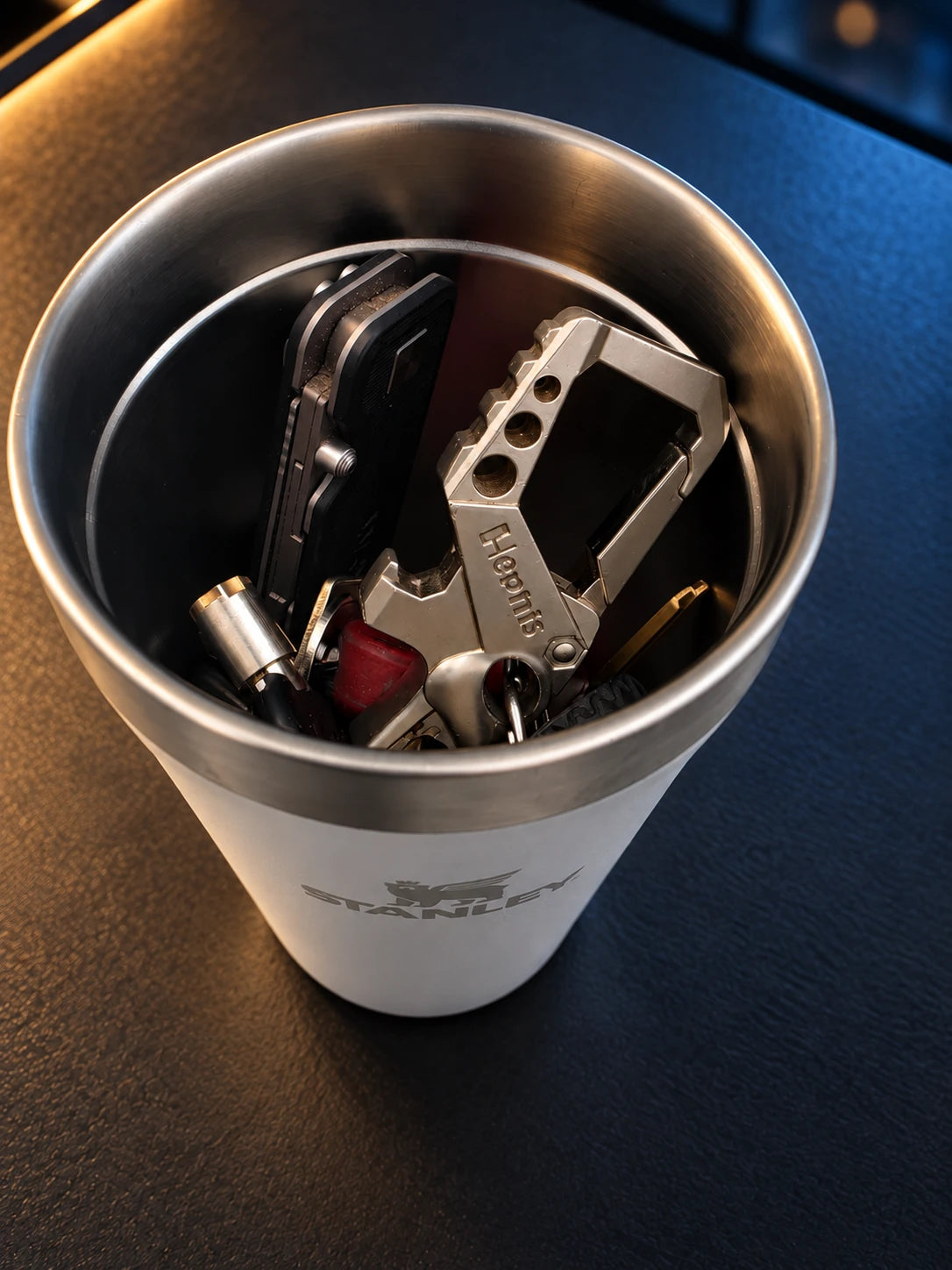 Keys stored inside a tumbler beneath the NMT replacement lid, on a charcoal desk.