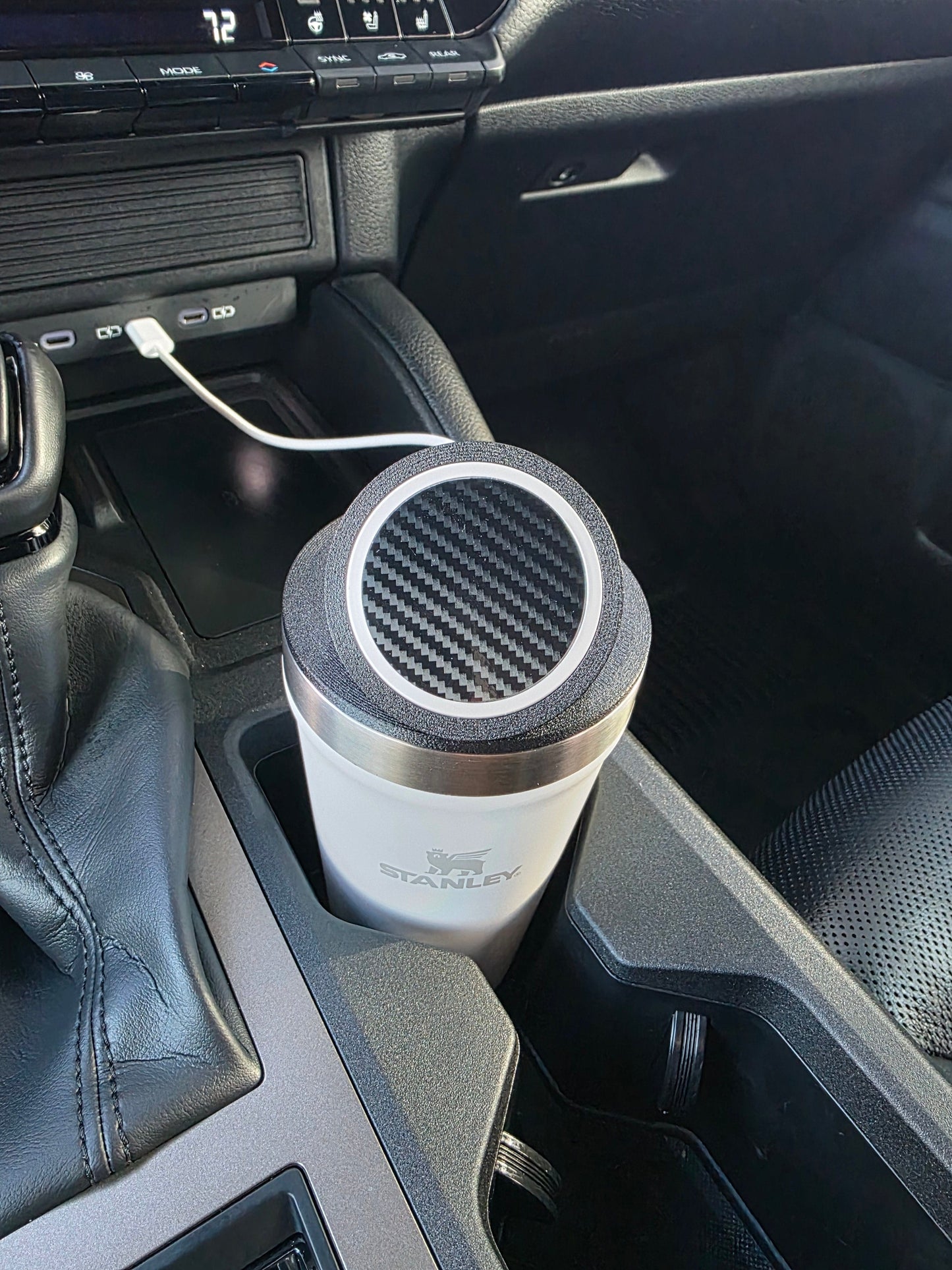 White Stanley 16 oz cup with the MagSafe stand lid tilted up in a truck console cupholder