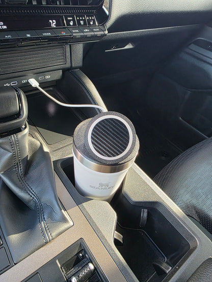 White Stanley 16 oz cup with the MagSafe stand lid in a sunlit truck cupholder, cable running to the dash