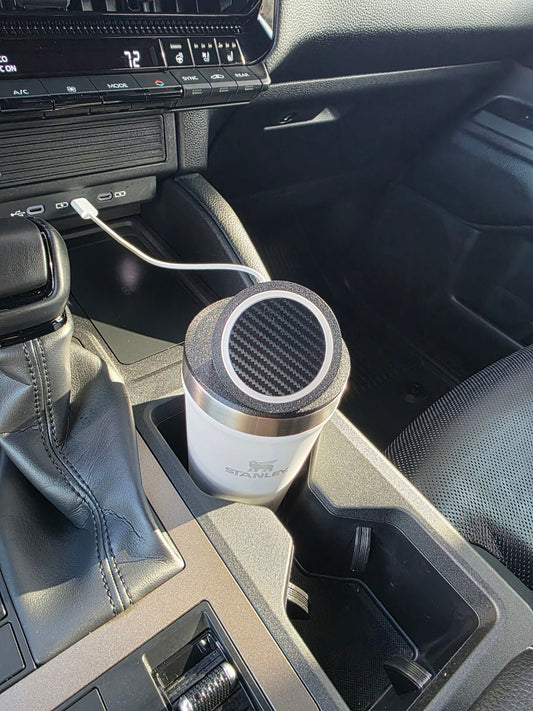 White Stanley 16 oz cup with the MagSafe stand lid in a sunlit truck cupholder, cable running to the dash