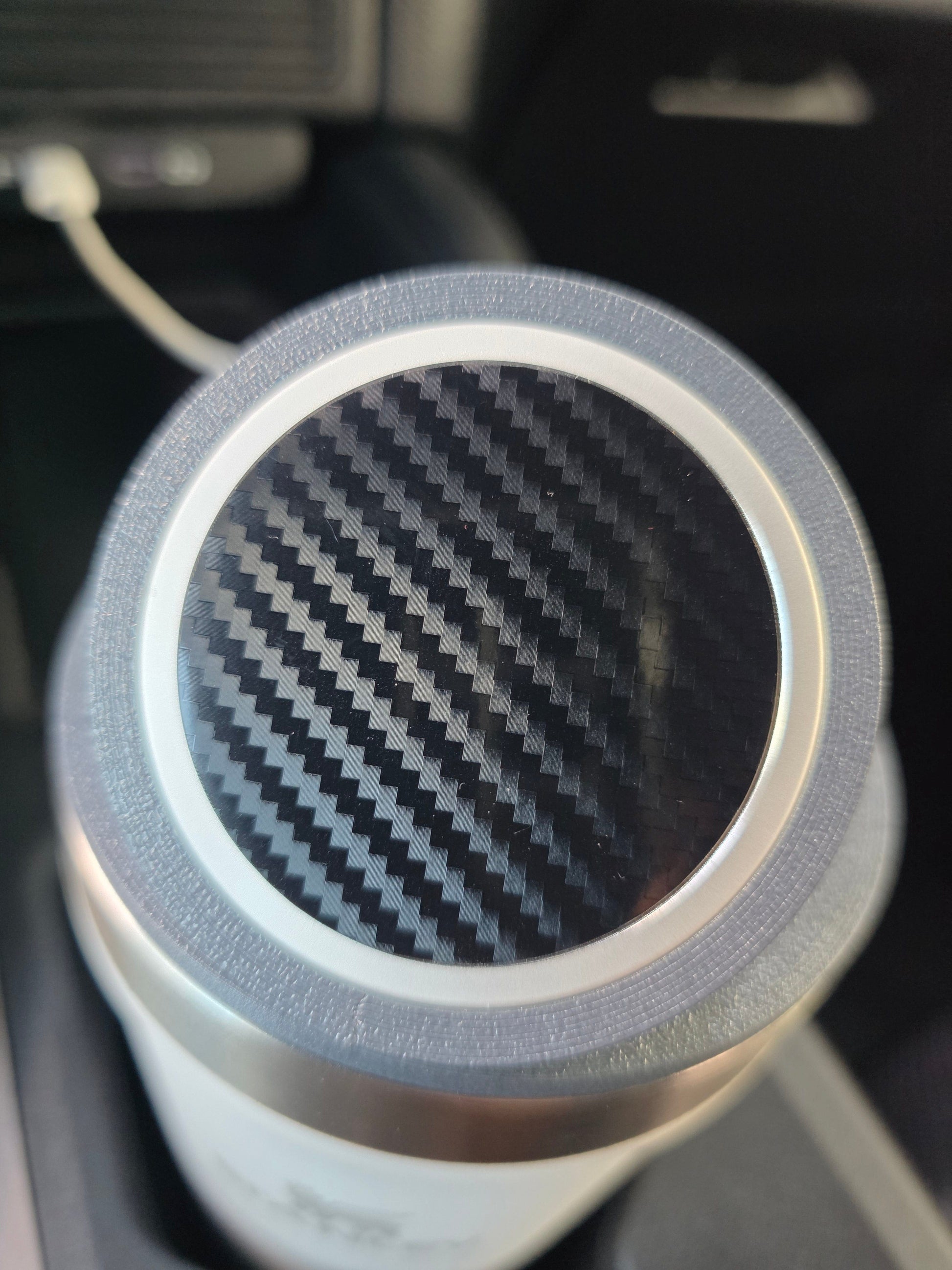 Close-up of the MagSafe stand's magnetic pad on a white cup in a truck cupholder