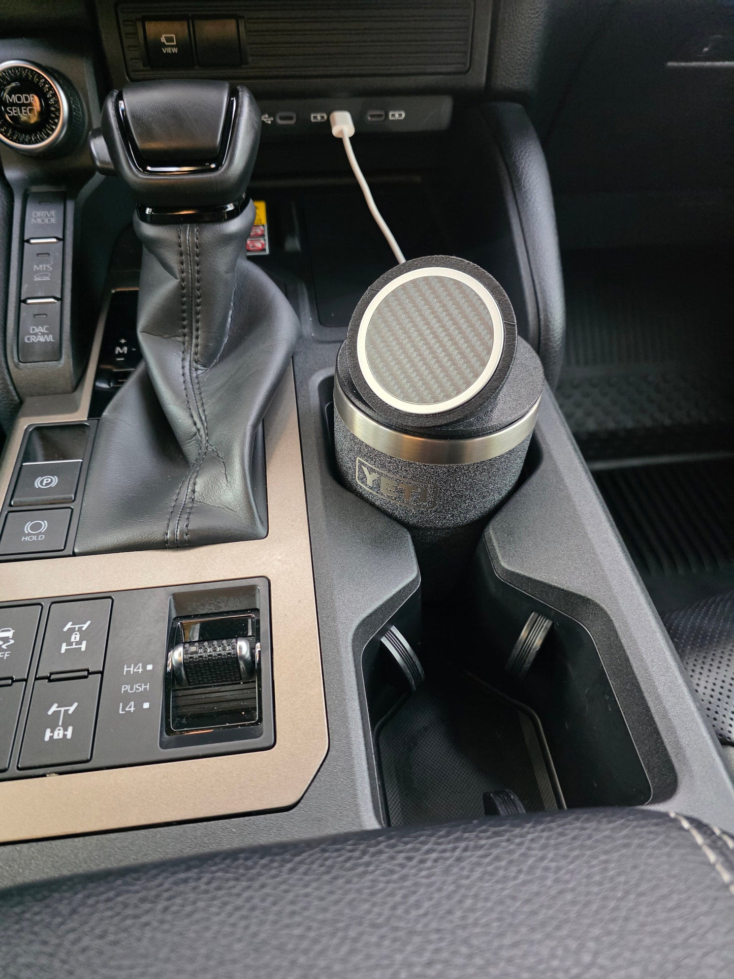 YETI cup with the black MagSafe stand lid in a truck cupholder, cable plugged into the dash port