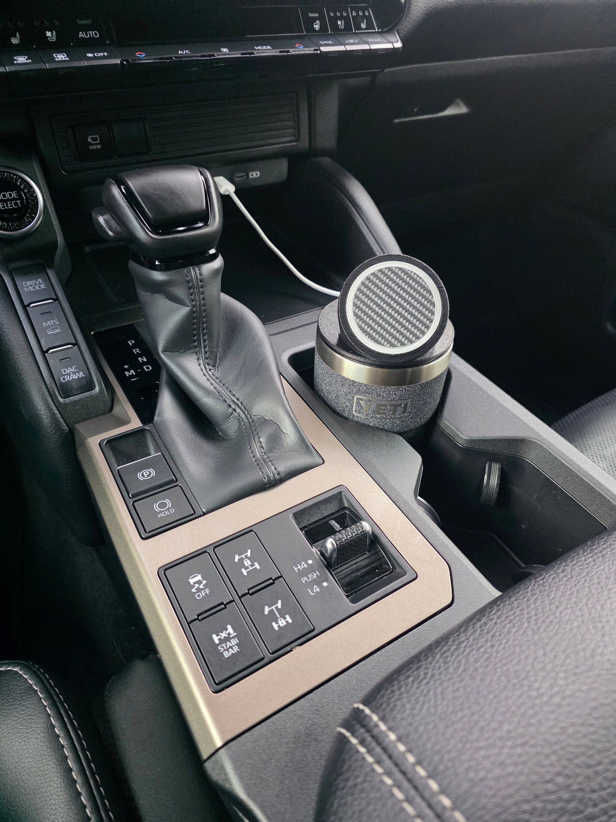 MagSafe stand lid on a YETI cup in a truck console cupholder, cable connected to the dash USB port