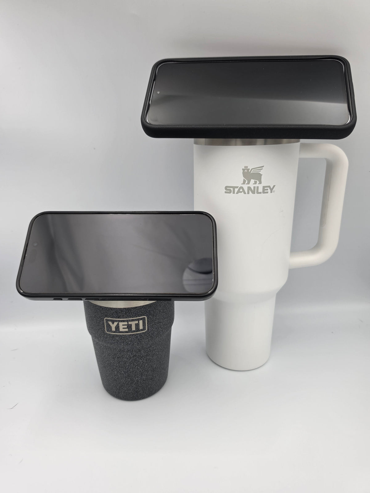 Two tumblers with phones mounted sideways in landscape orientation
