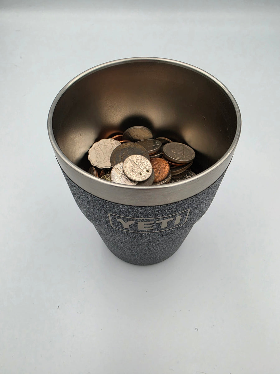 A YETI tumbler with the mount removed, filled with loose coins