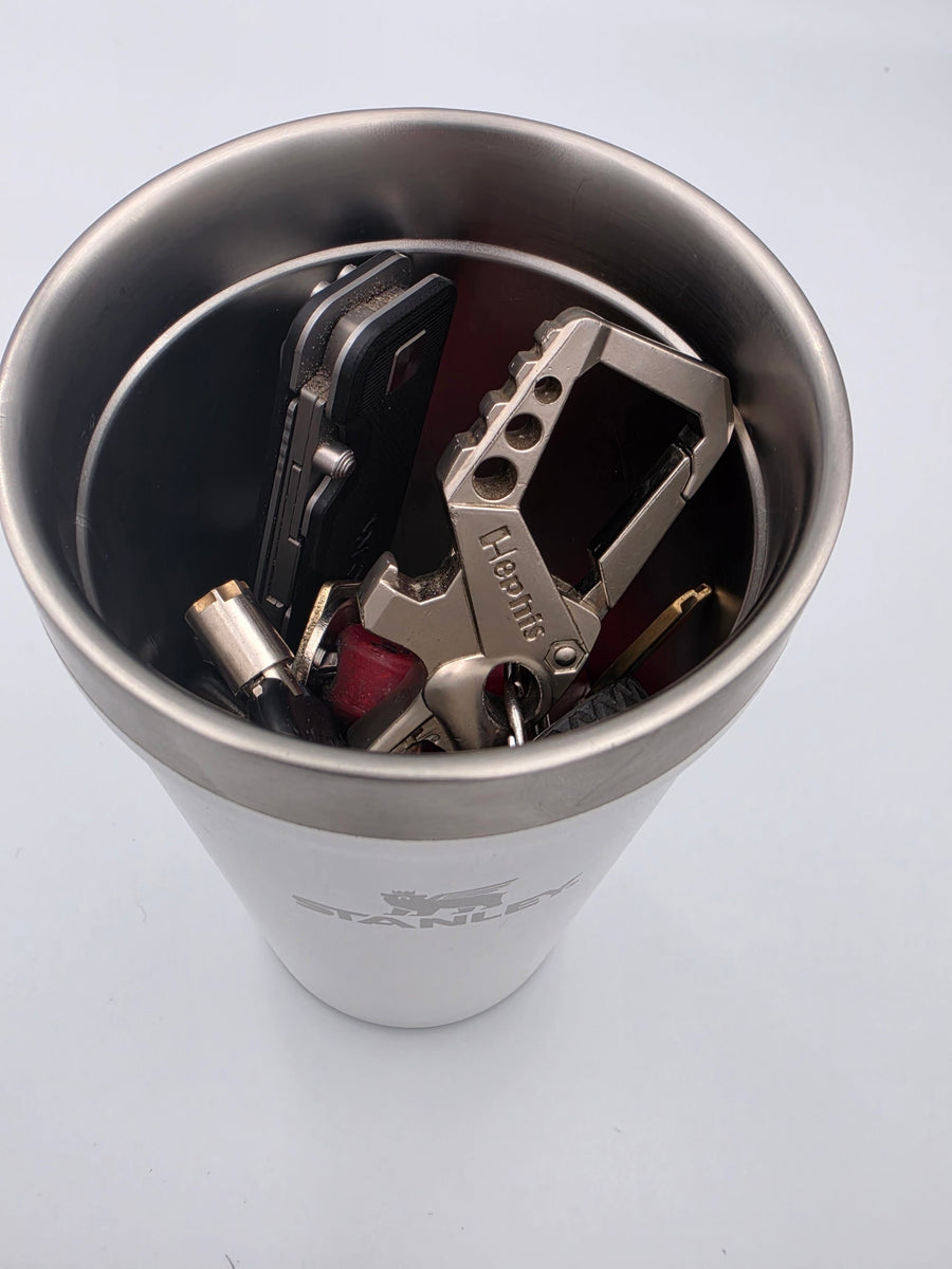 A tumbler with the mount removed, holding keys and a multitool inside