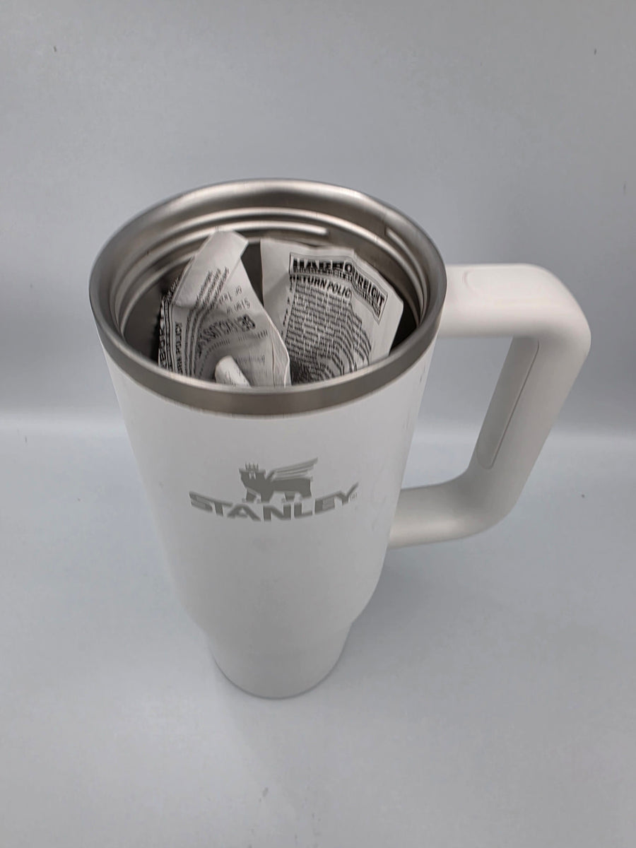 A Stanley tumbler with the mount removed, holding folded receipts inside
