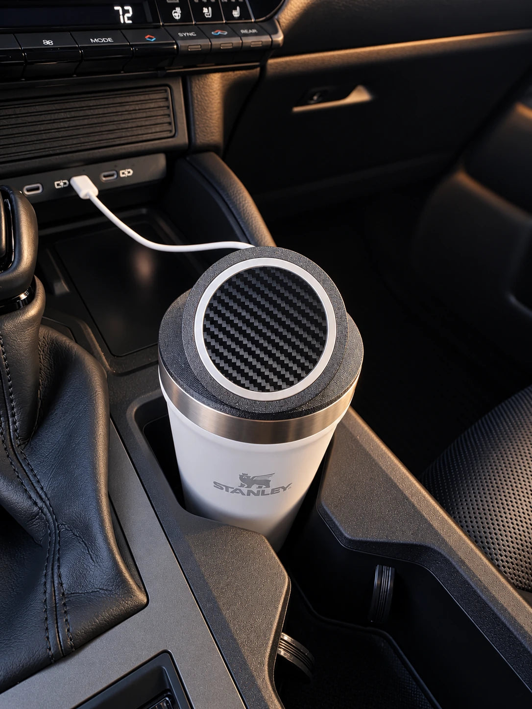 White Stanley Everyday Tumbler with an NMT mount and charging puck fitted in a vehicle cupholder.