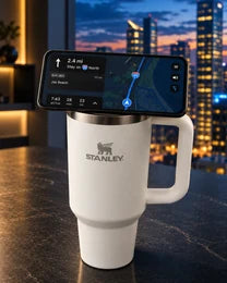Phone docked on an NMT replacement lid fitted to a Stanley Quencher at a city office desk.