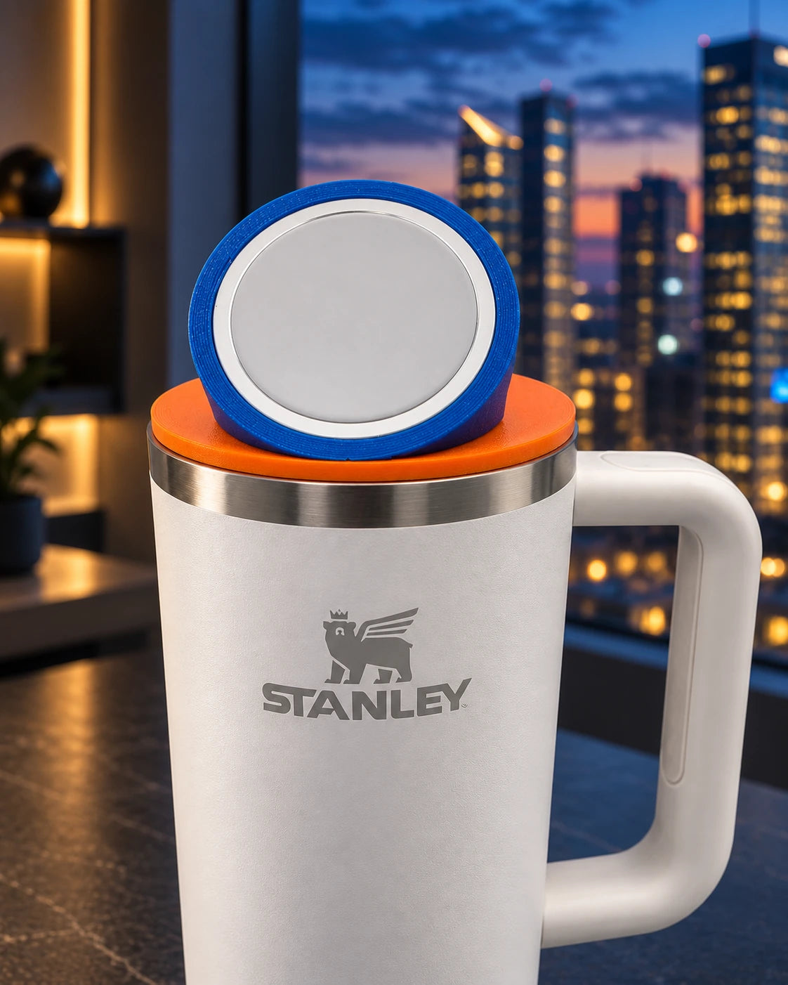 Blue NMT Top Ring around a charging puck, shown with an orange mount and white Stanley cup.