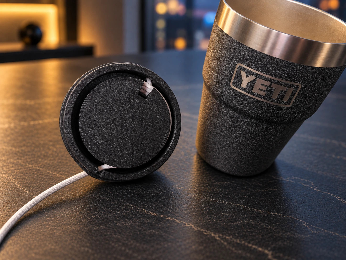 Underside of the NMT lid showing cable routing beside an empty YETI cup.